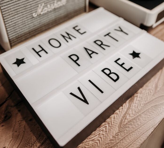 Lightbox sign with 'Home Party Vibe' near vintage record player and speaker.
